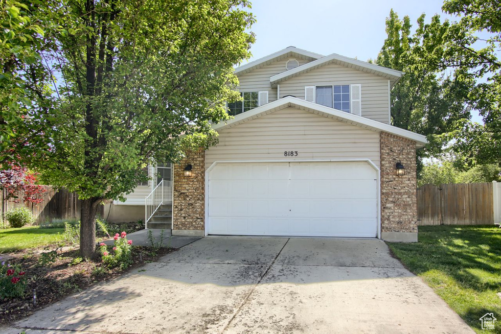 View of front of home featuring brick siding, an attached garage, and concrete driveway