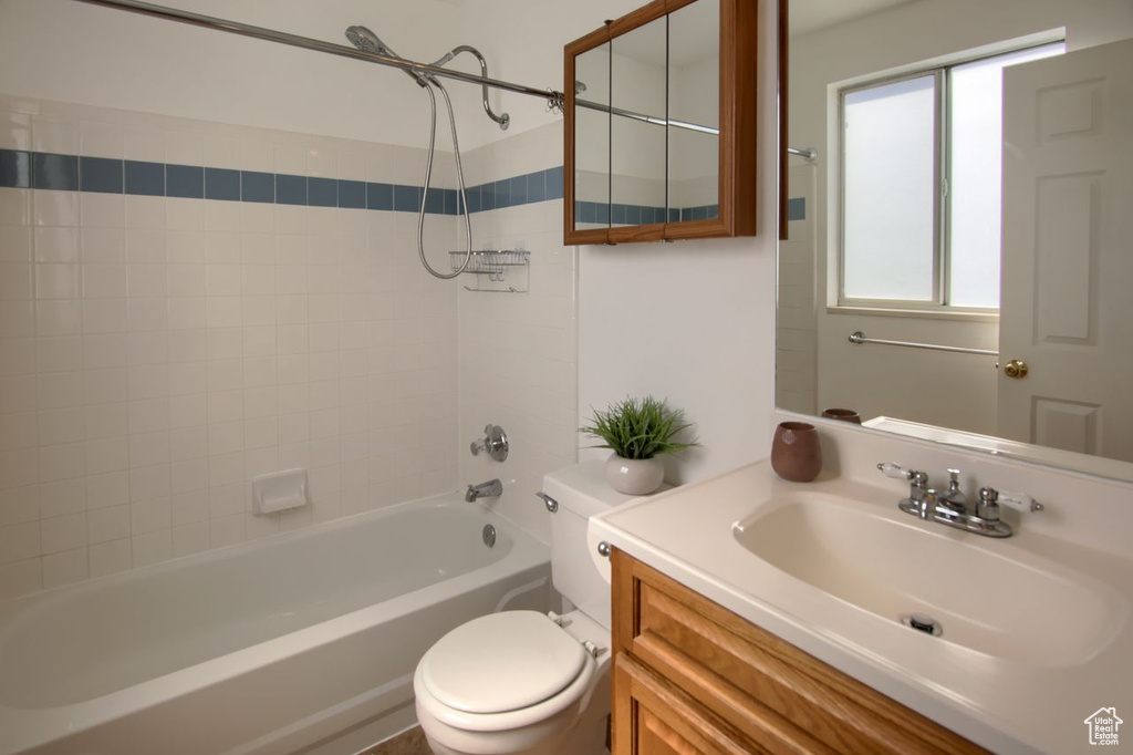 Full bathroom with toilet, washtub / shower combination, and vanity