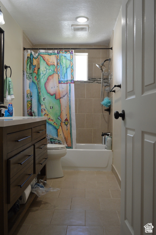 Bathroom with shower / bathtub combination with curtain, toilet, vanity, and a textured ceiling