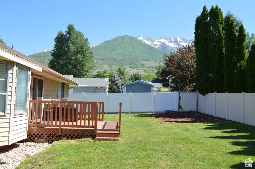 View of yard with a deck with mountain view