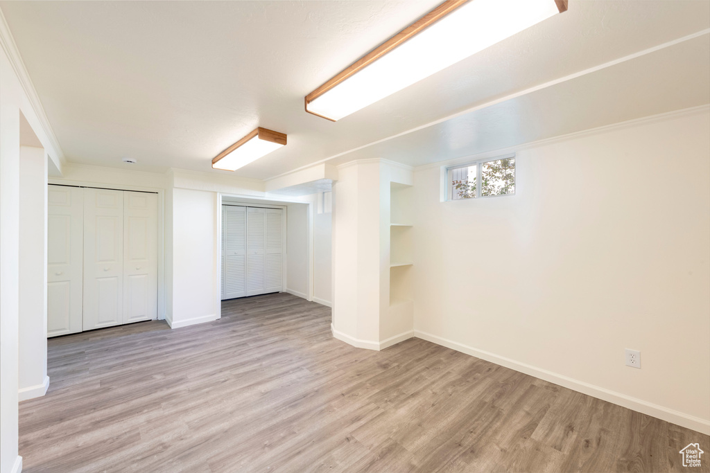 Basement with light wood finished floors and baseboards