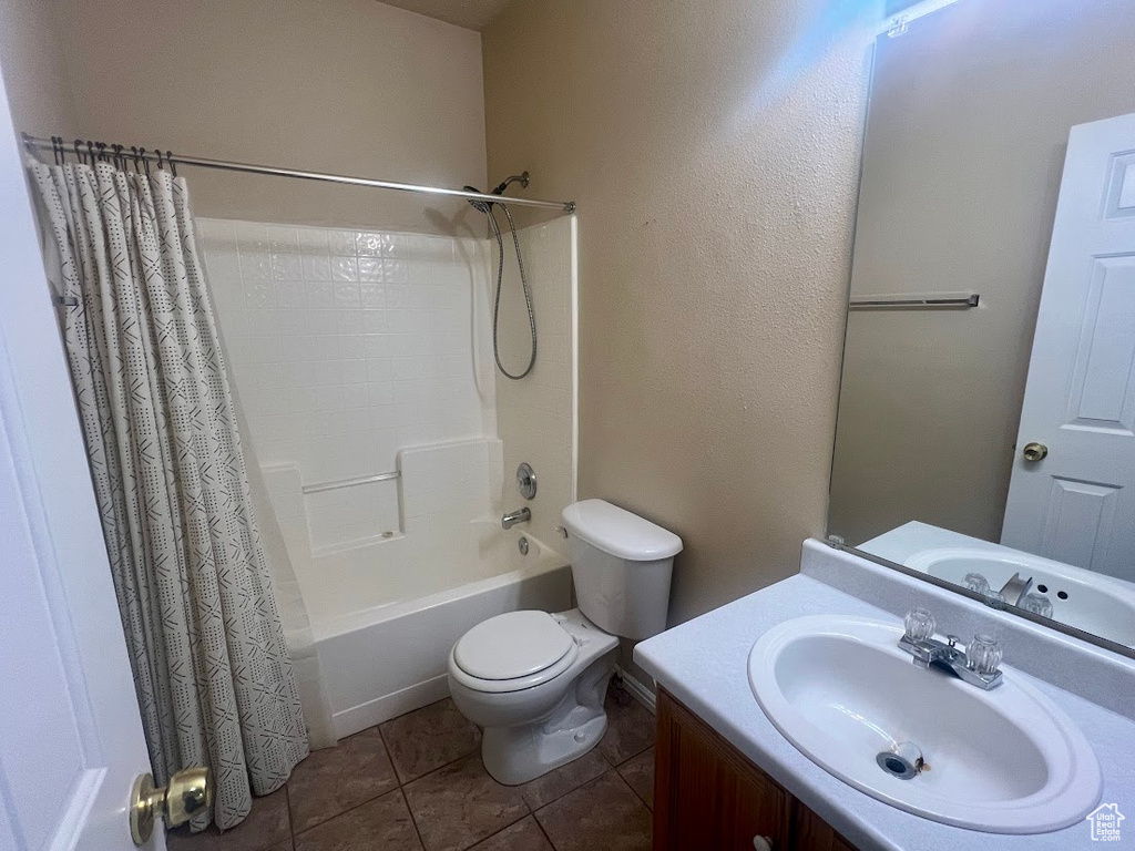 Full bathroom featuring toilet, shower / bath combination with curtain, vanity, and tile patterned floors