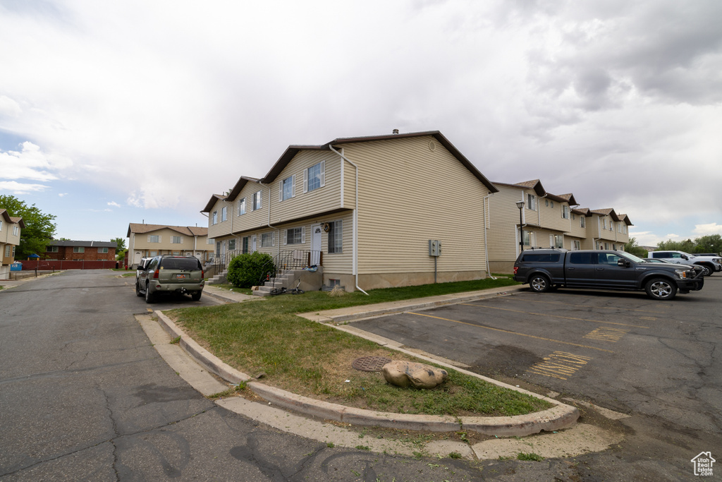 View of side of property featuring uncovered parking and a residential view