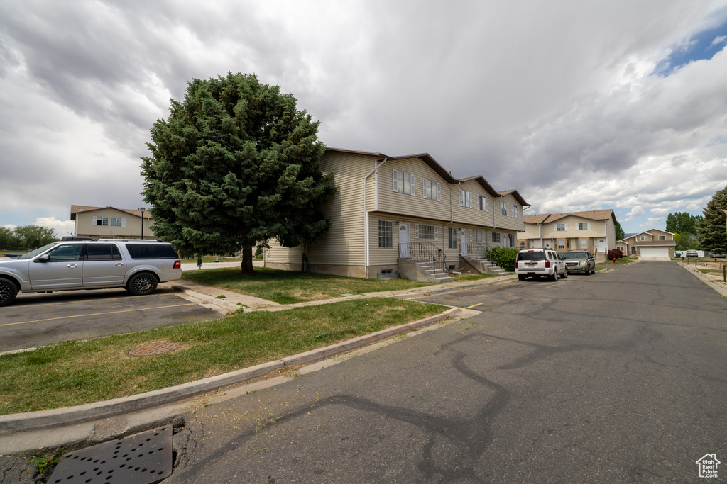 View of asphalt street featuring curbs and a residential view