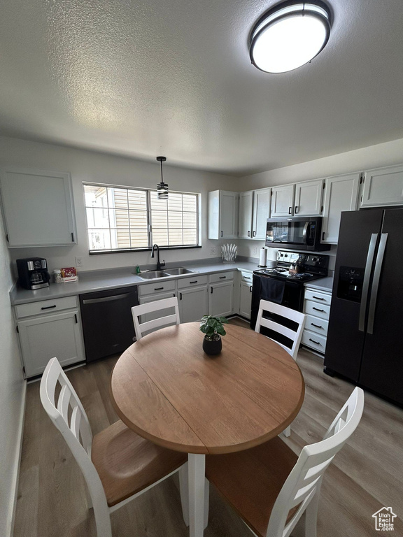 Kitchen with dishwasher, stainless steel fridge, black microwave, a sink, and range