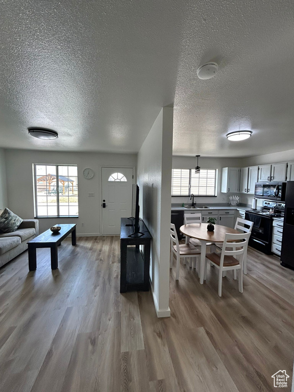 Living room featuring a textured ceiling, light wood finished floors, and baseboards