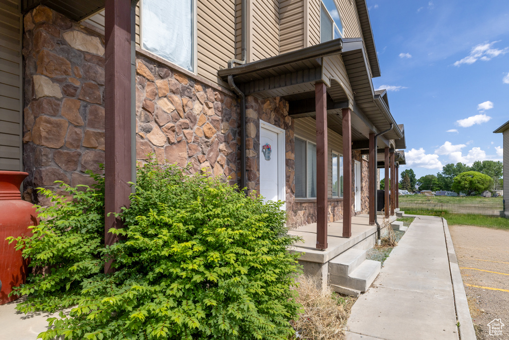 Property entrance featuring stone siding and covered porch