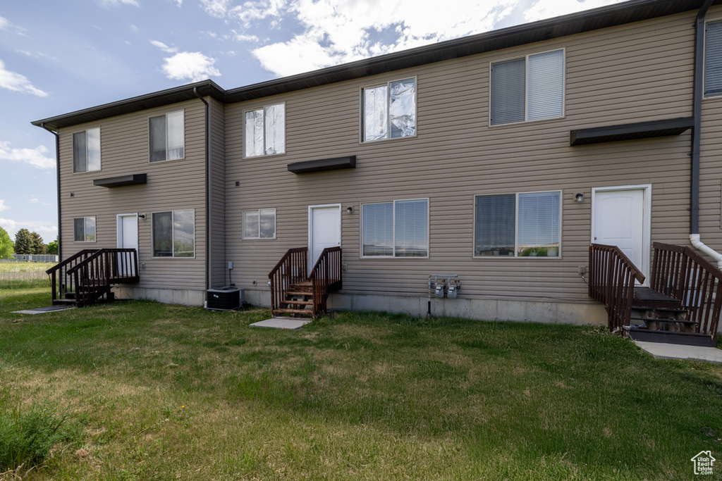 Back of house featuring a yard and cooling unit