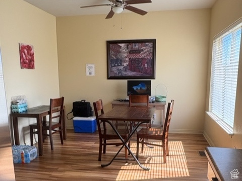 Dining space with wood finished floors and a ceiling fan