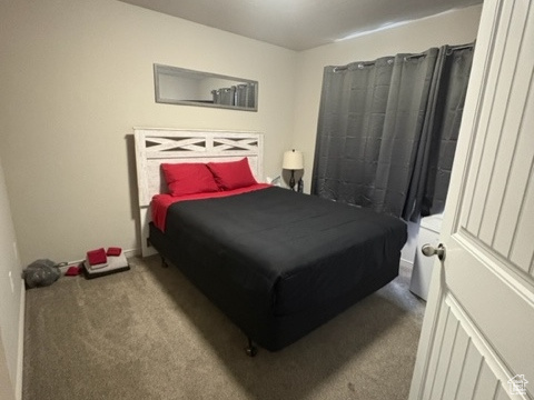 Carpeted bedroom featuring a textured ceiling and baseboards