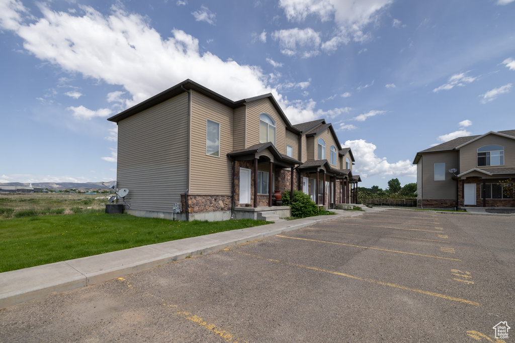 View of front of home with uncovered parking and stone siding