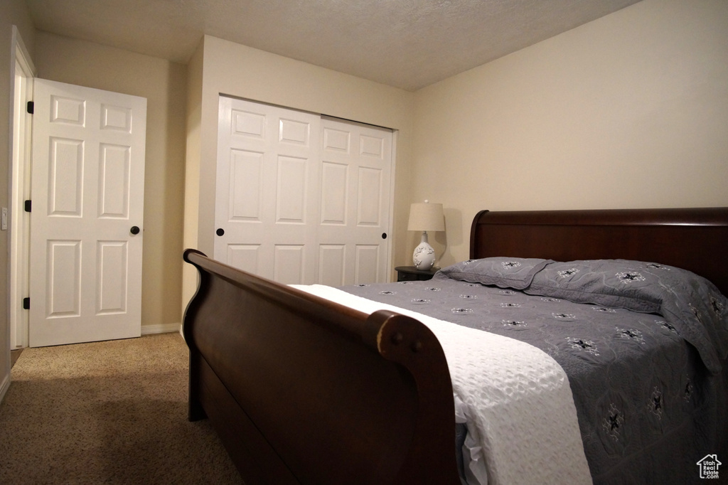 Carpeted bedroom featuring a closet and baseboards