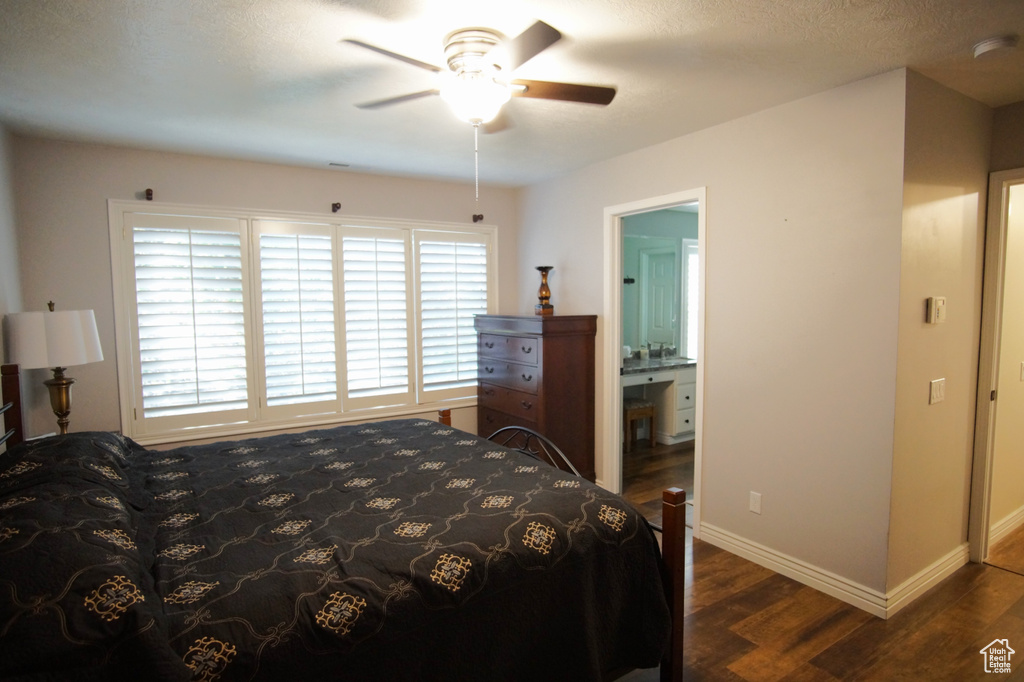 Bedroom featuring dark wood-style floors, multiple windows, and baseboards