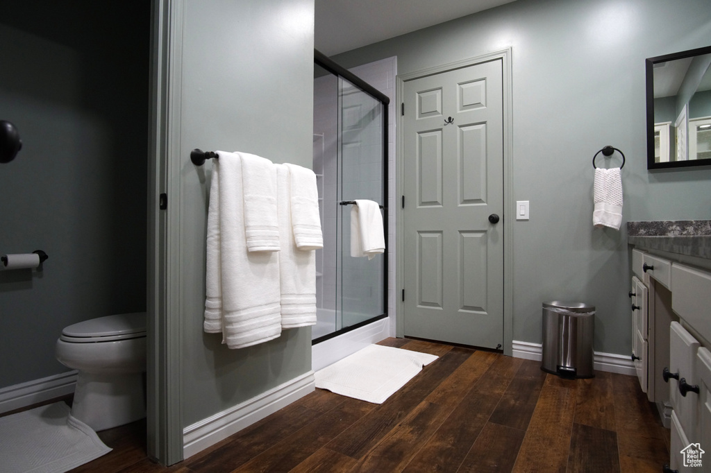 Bathroom with vanity, wood finished floors, a shower stall, and toilet