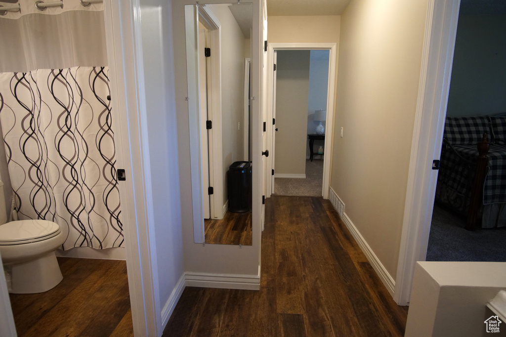 Hall with dark wood finished floors and baseboards
