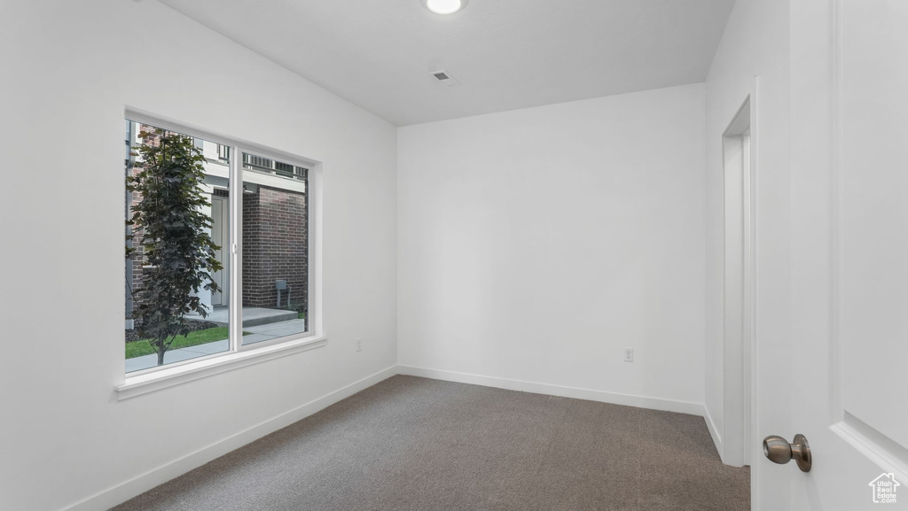 Empty room with carpet and baseboards