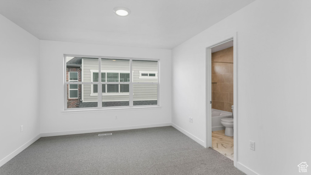 Spare room featuring carpet flooring and baseboards