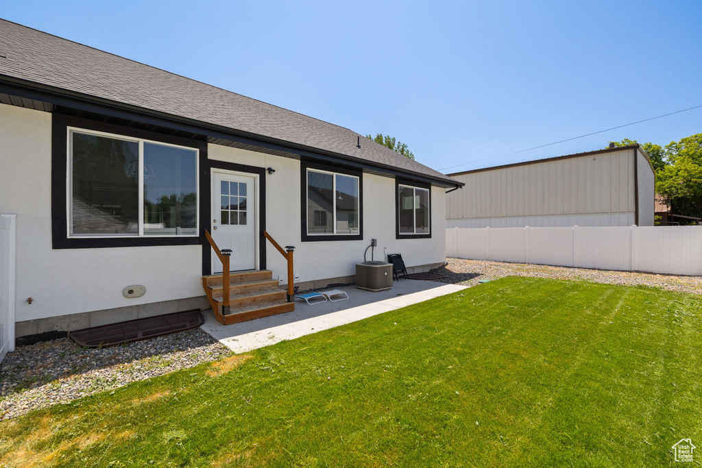 Back of property with entry steps, roof with shingles, and stucco siding