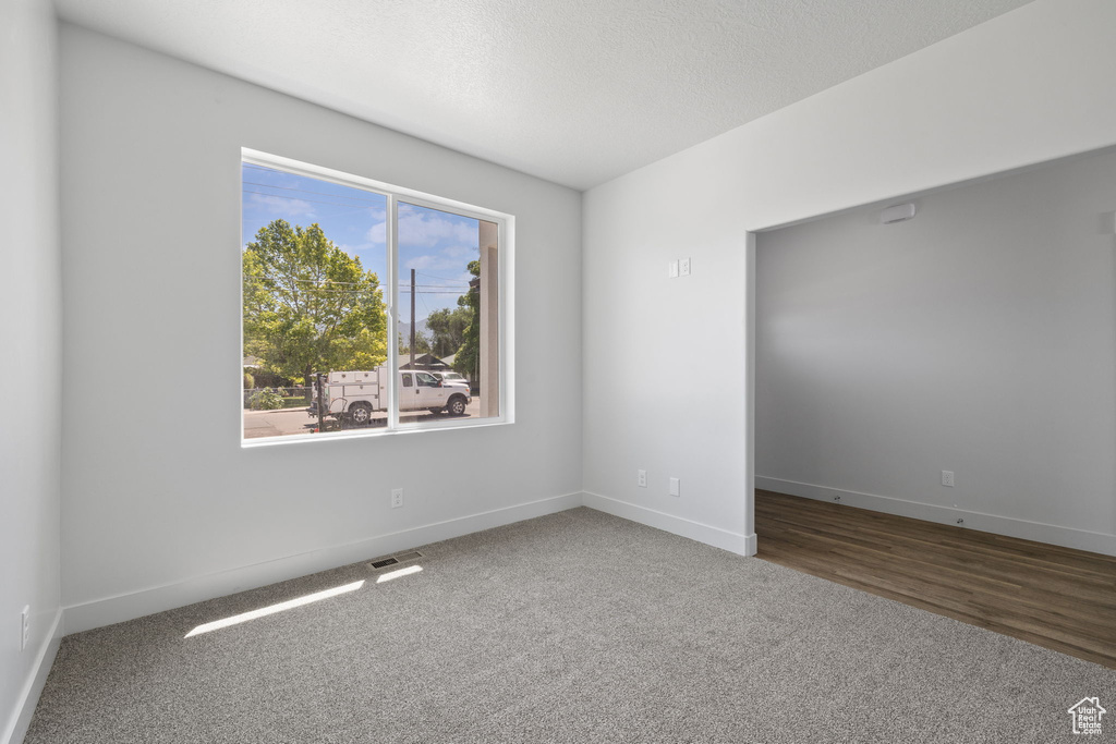 Carpeted spare room with baseboards and a textured ceiling