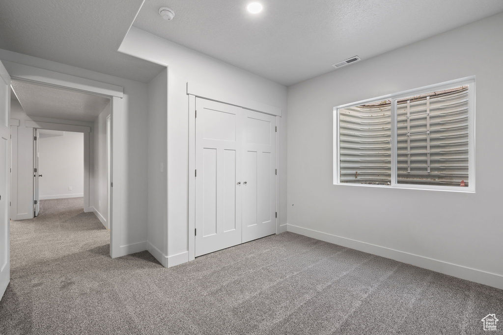 Unfurnished bedroom with carpet flooring and a closet