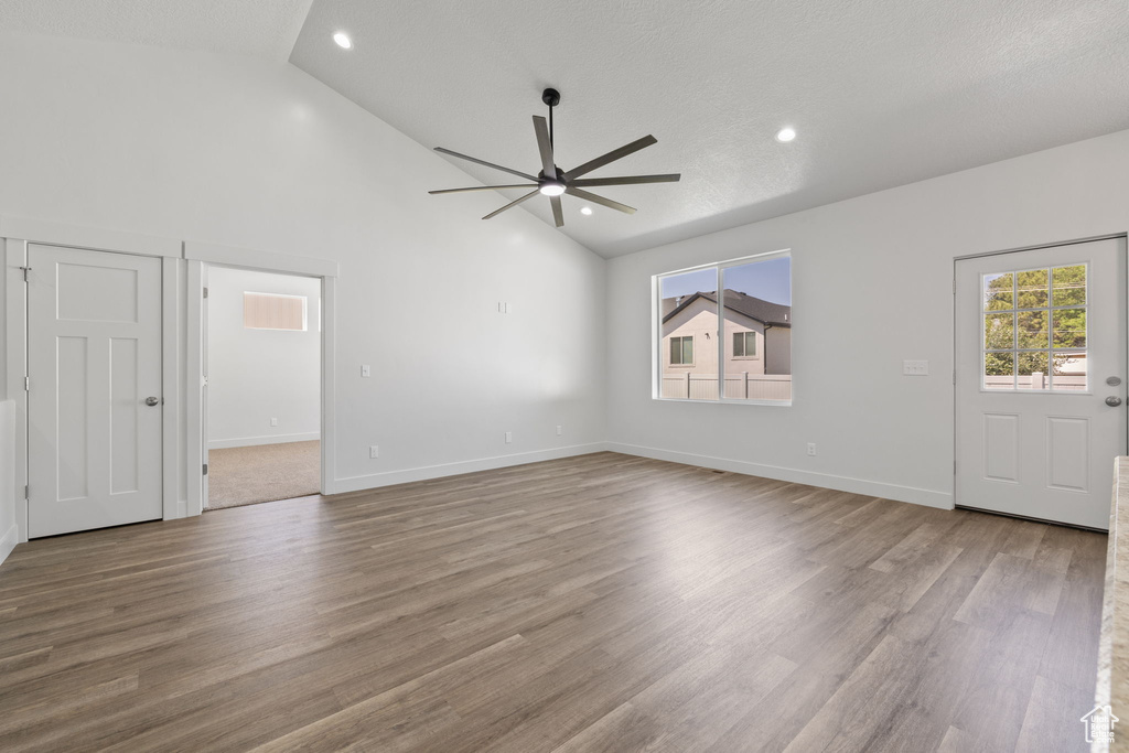 Unfurnished living room with a ceiling fan, wood finished floors, recessed lighting, and high vaulted ceiling