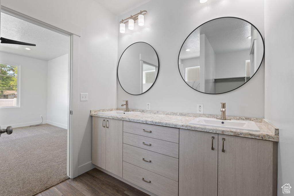 Full bathroom with double vanity and wood finished floors
