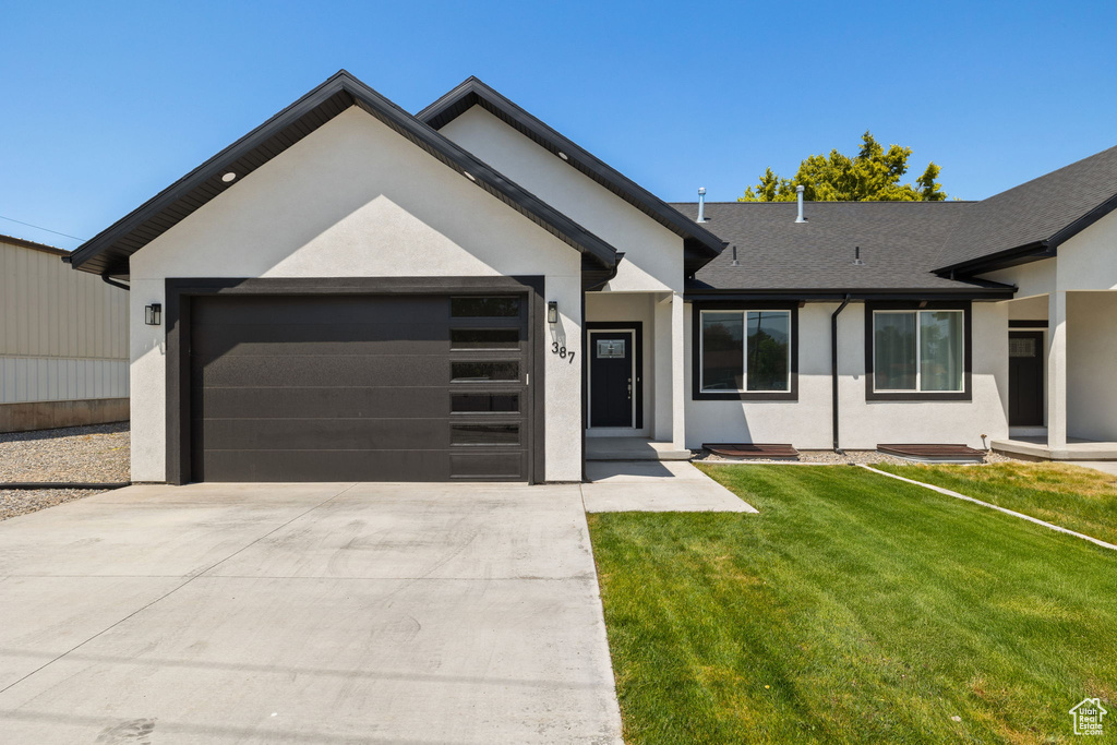 Single story home featuring stucco siding, concrete driveway, an attached garage, and a front yard