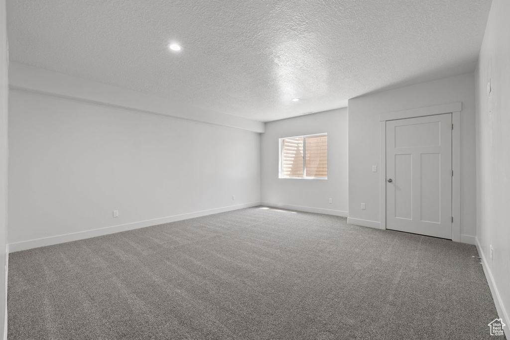Unfurnished room featuring a textured ceiling, carpet floors, and recessed lighting