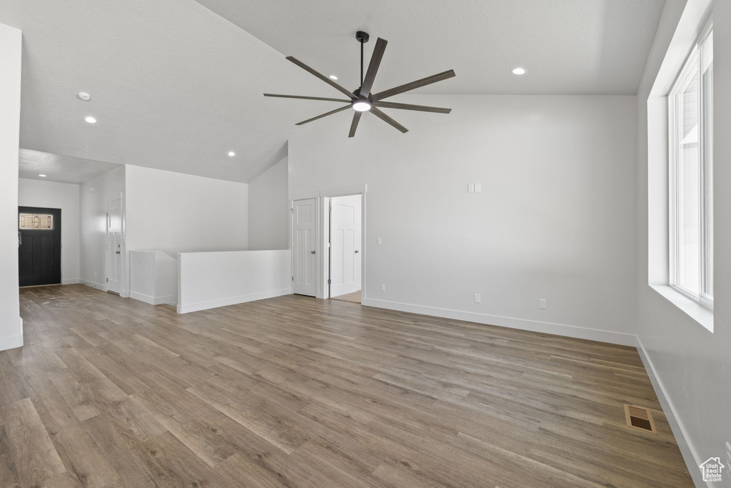 Unfurnished living room featuring a ceiling fan, wood finished floors, recessed lighting, and vaulted ceiling
