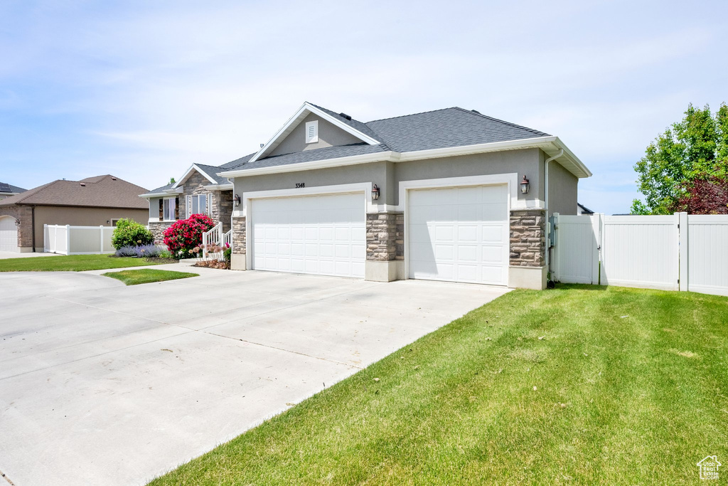 View of front of house featuring stone siding, concrete driveway, a garage, stucco siding, and a shingled roof