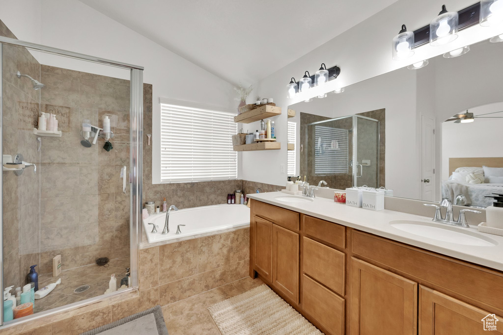 Full bath with a garden tub, vaulted ceiling, a stall shower, double vanity, and ceiling fan