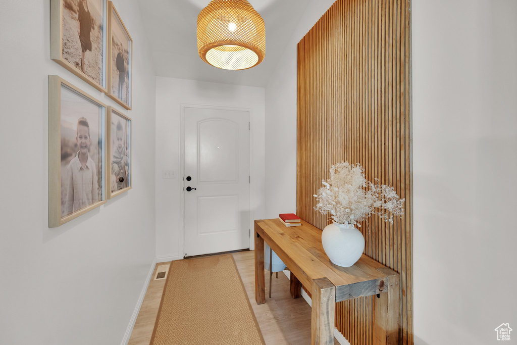 Doorway with baseboards and light wood-type flooring