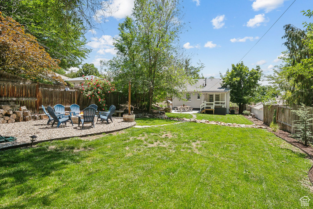 View of yard with an outdoor fire pit and a patio