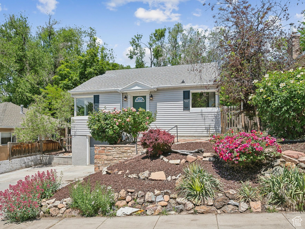 View of front of house featuring driveway and roof with shingles