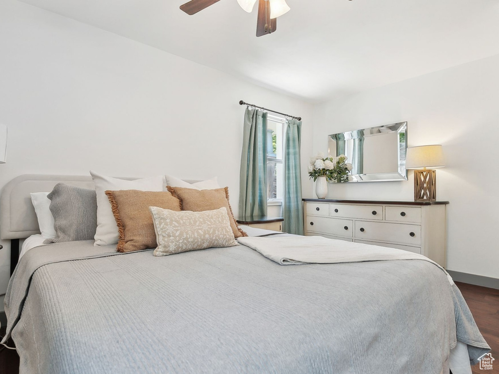 Bedroom with dark wood-type flooring, baseboards, and ceiling fan