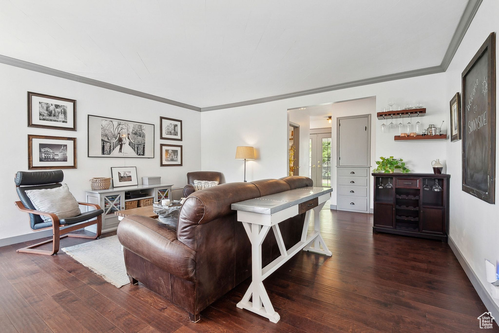 Living room featuring crown molding, wood finished floors, and baseboards