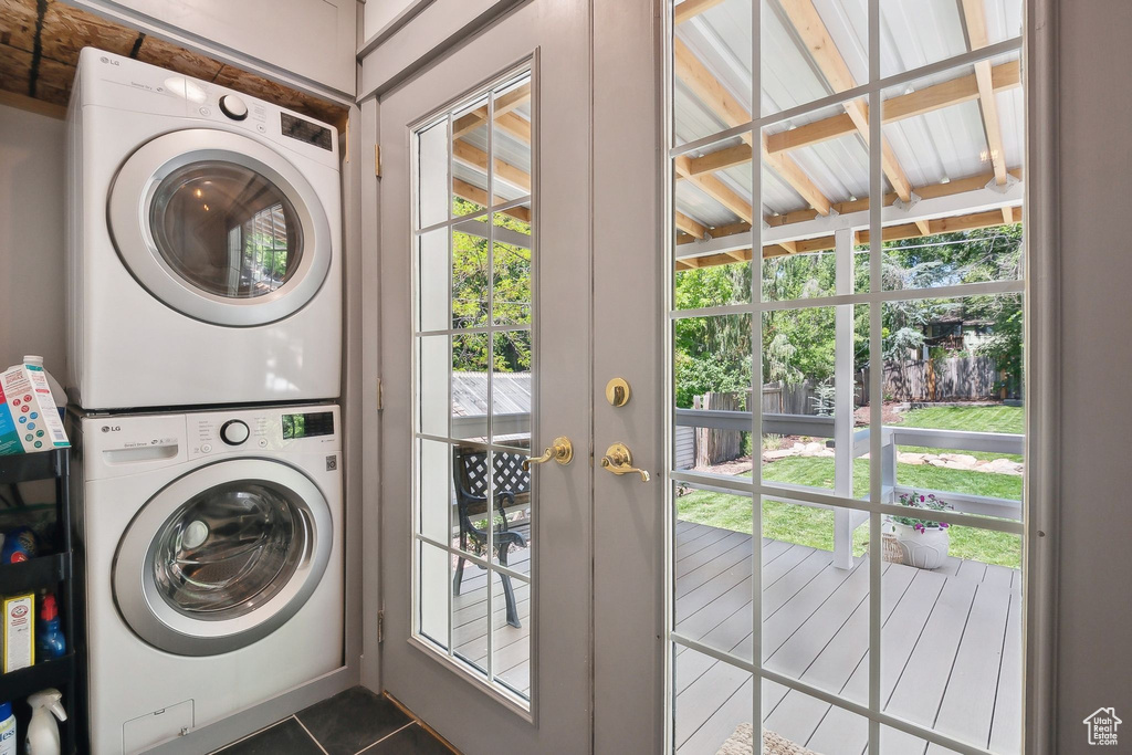 Laundry room featuring stacked washing machine and dryer and tile patterned floors