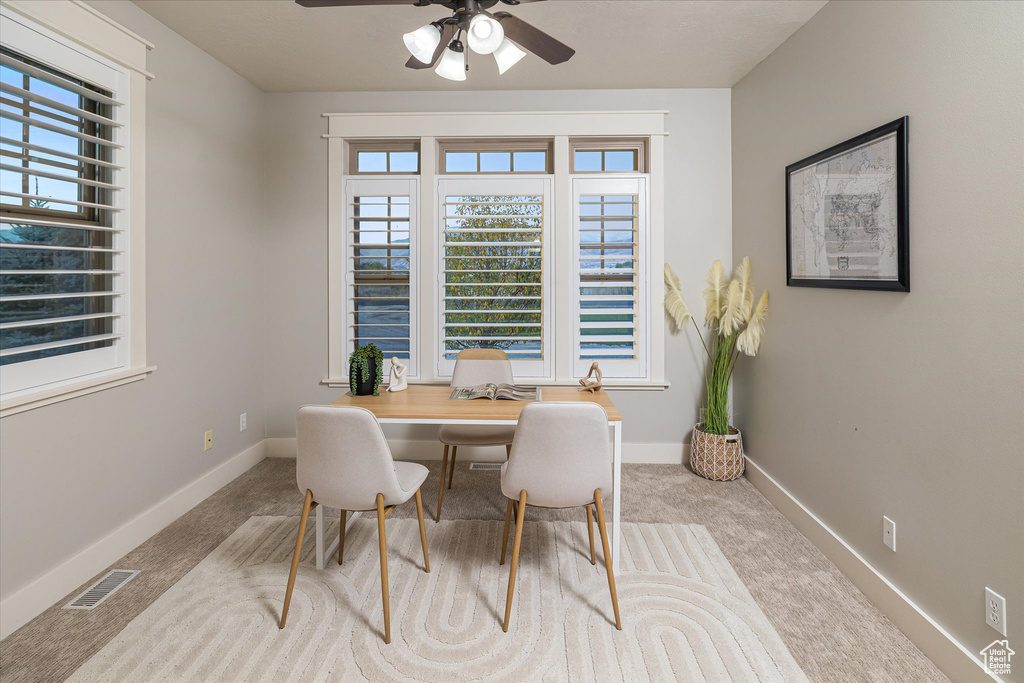 Dining area featuring ceiling fan, carpet, baseboards, and a desk