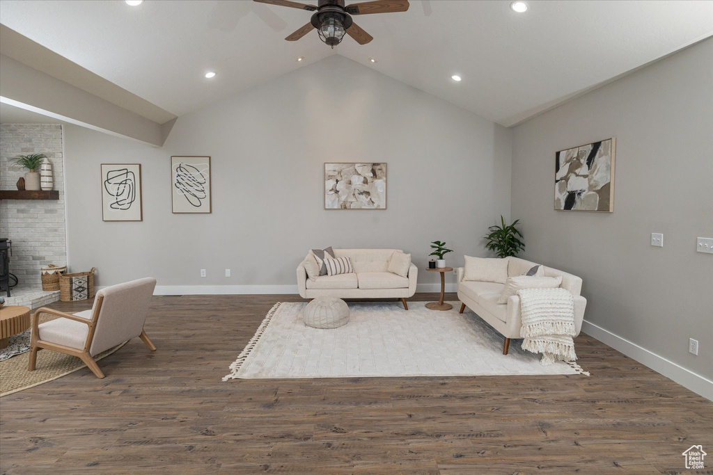 Living area featuring recessed lighting, ceiling fan, baseboards, a wood stove, and lofted ceiling
