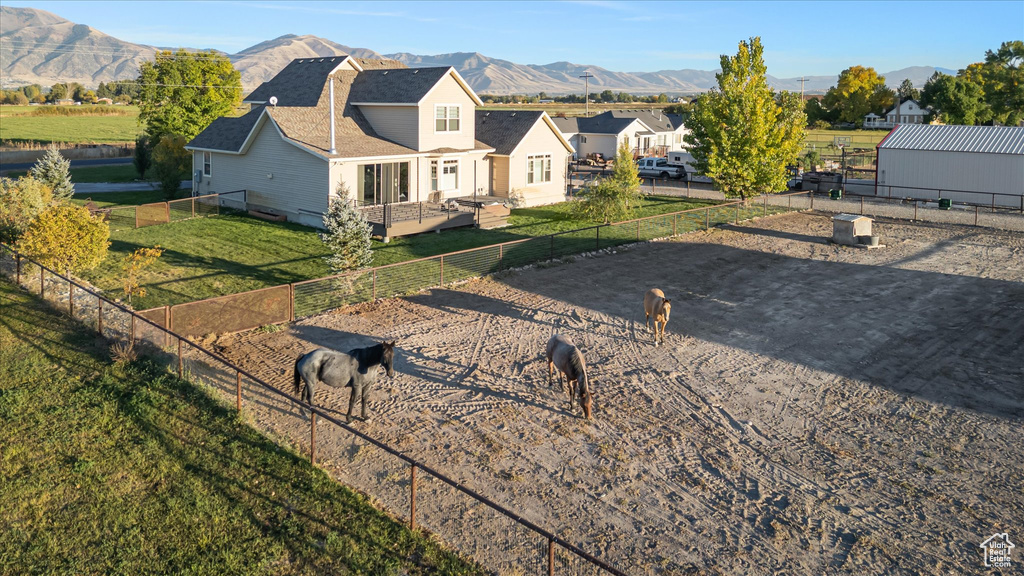 View of front of property featuring roof with shingles and a deck with mountain view