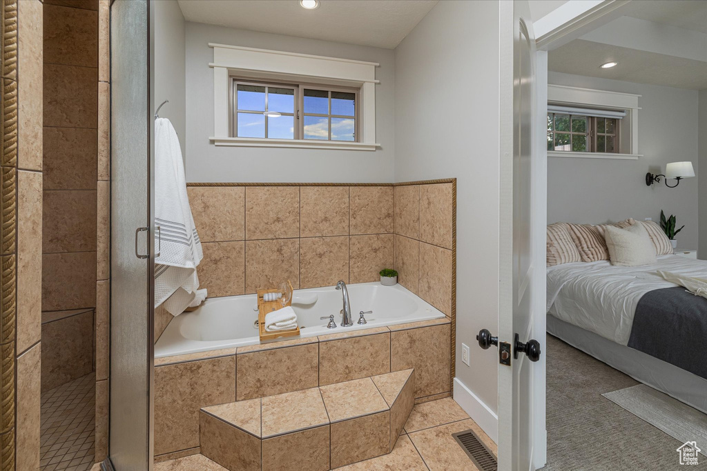 Ensuite bathroom with a bath, plenty of natural light, tile patterned flooring, a shower stall, and recessed lighting