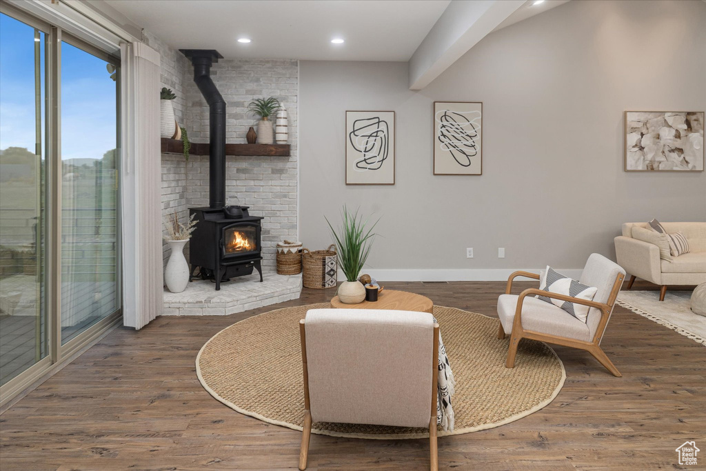 Living room featuring a wood stove, baseboards, recessed lighting, and wood finished floors