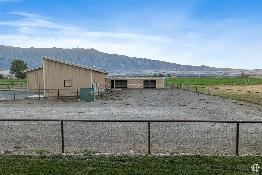 View of side of home featuring a mountain view, an exterior structure, and a view of countryside