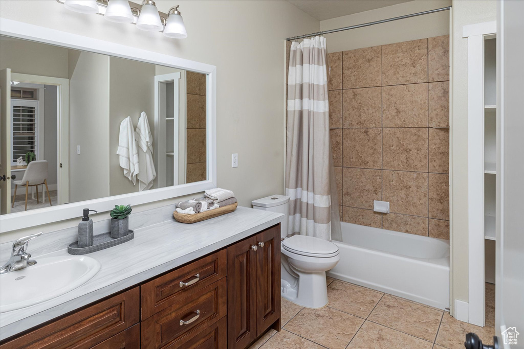 Bathroom with vanity, tile patterned flooring, shower / bath combination with curtain, and toilet