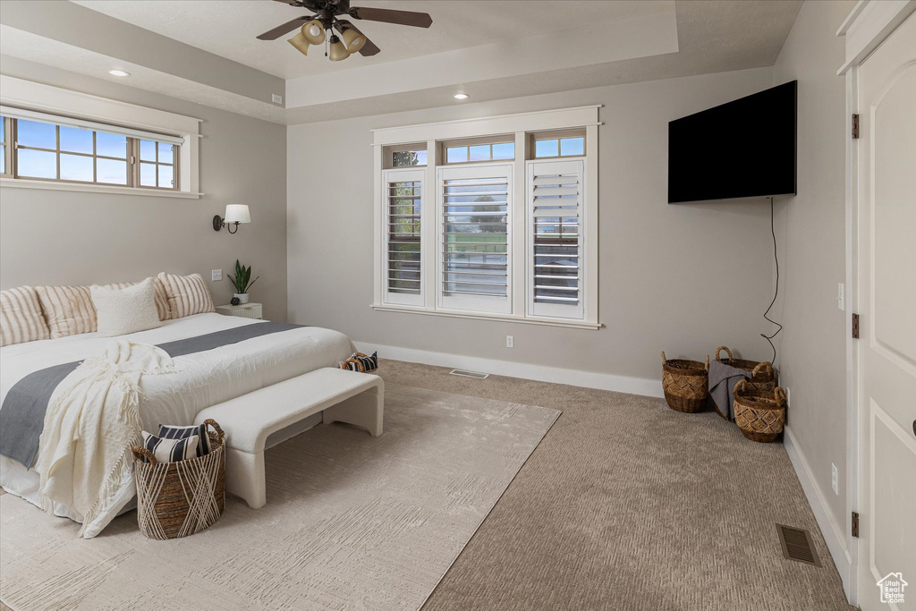 Bedroom with carpet flooring, a raised ceiling, baseboards, recessed lighting, and ceiling fan