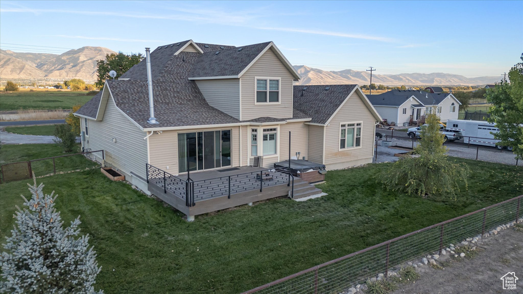 Back of house featuring a deck with mountain view and a shingled roof