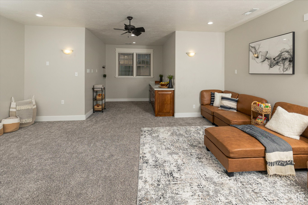 Living area featuring ceiling fan, baseboards, recessed lighting, and carpet