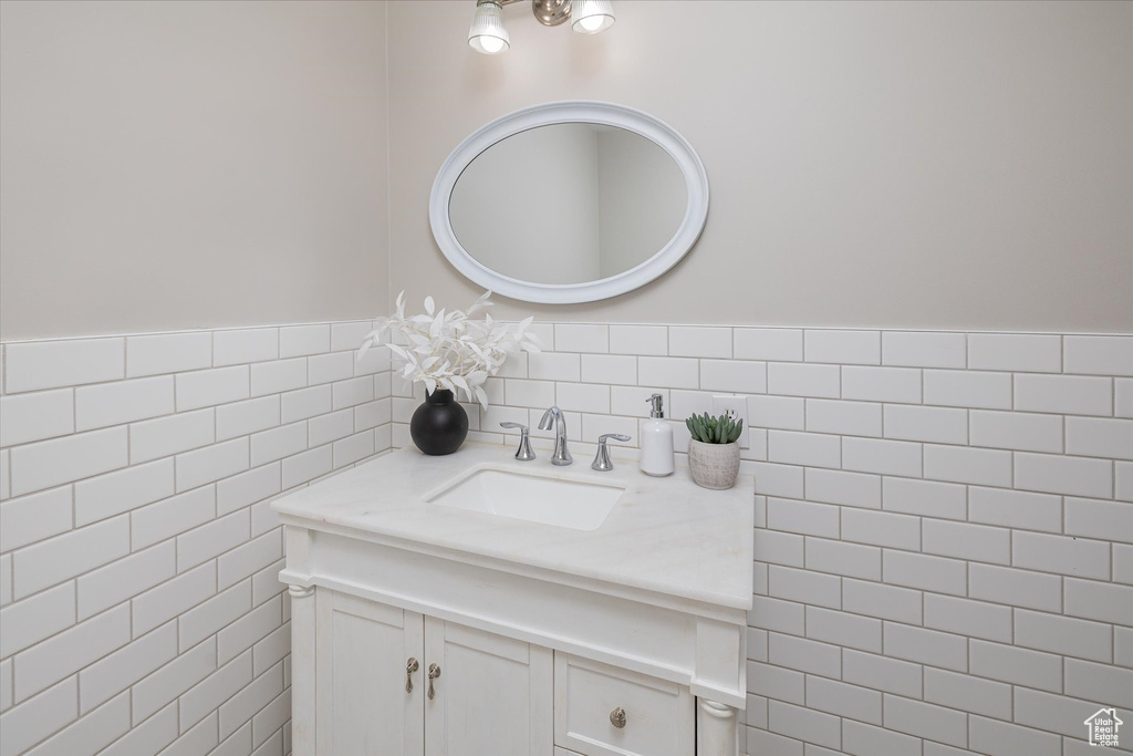 Bathroom featuring vanity and tile walls