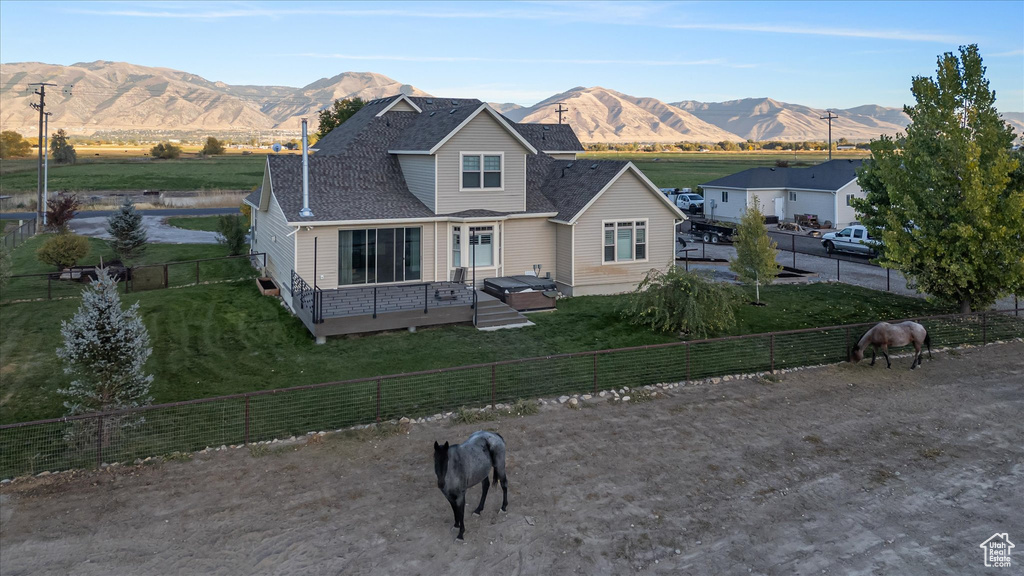 Traditional-style house with a view of countryside, a deck with mountain view, and roof with shingles