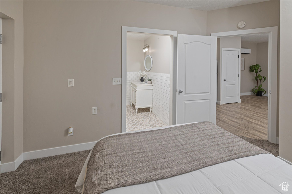 Bedroom with baseboards, a wainscoted wall, carpet flooring, and connected bathroom